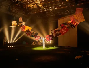 Eine Person streckt beide Arme zur Seite aus, die von aneinanderklebenden Wahlplakaten verlängert werden.