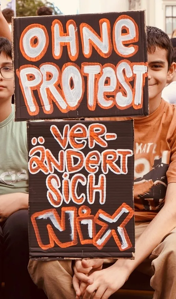 Plakate mit dem Text „Ohne Protest verändert sich nix"
