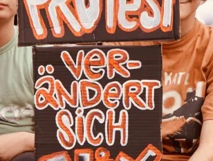 Plakate mit dem Text „Ohne Protest verändert sich nix"