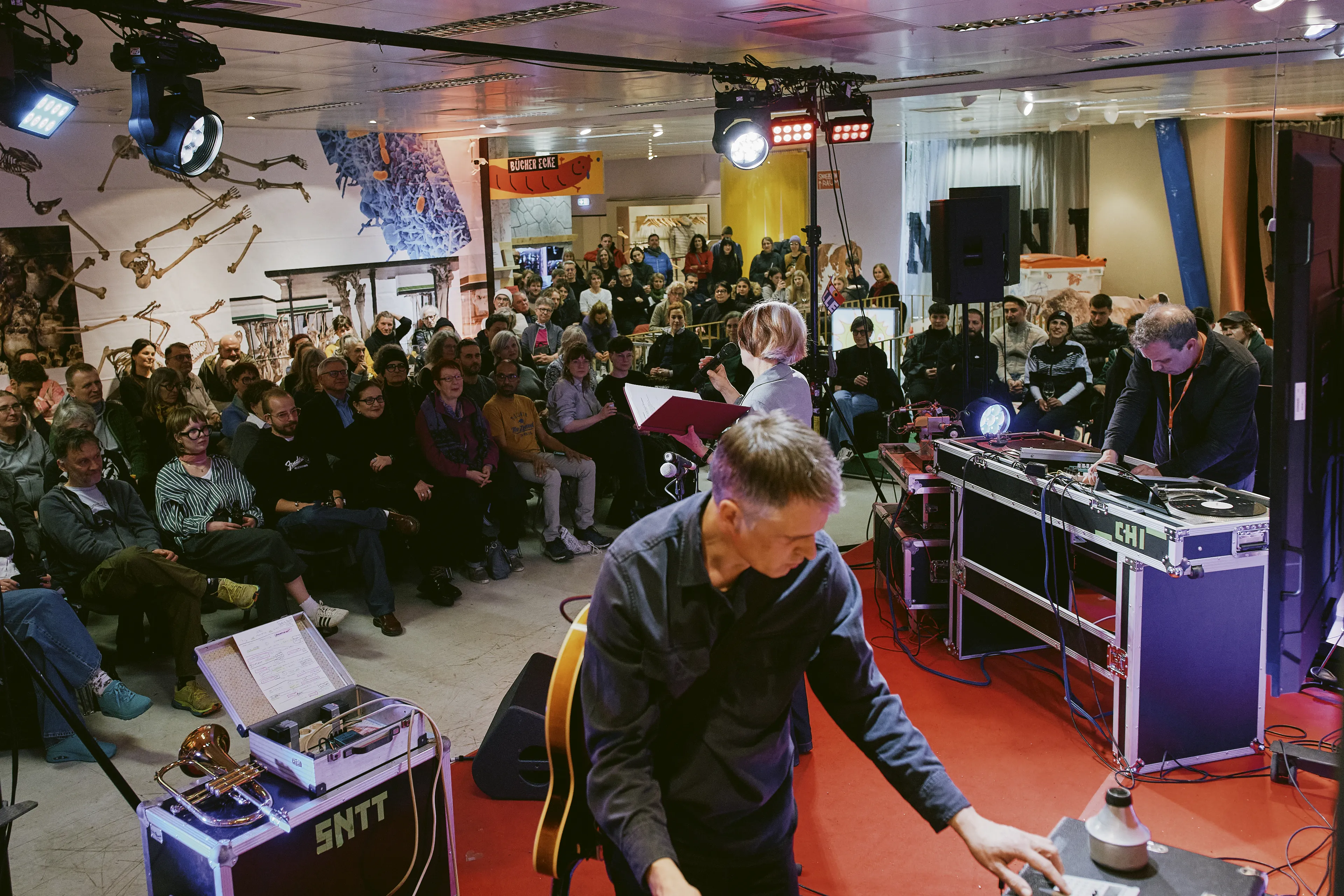 Die Schauspielerin Karla Andrä performt vor Publikum im Festivalzentrum Texte aus dem Gästebuch des Brechthauses mit musikalischer Untermalung von Moritz Illner und Markus Christ