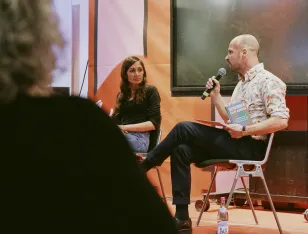 Der Moderator Martin Muth stellt der Autorin Gilda Sahebi im Rahmen der Lesung eine Frage.